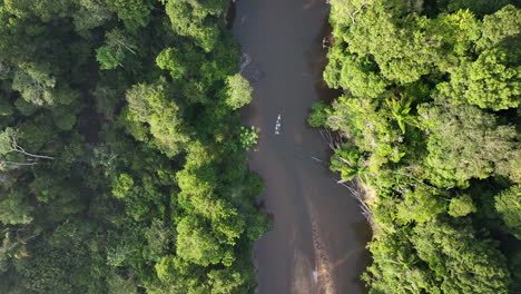Drone-follows-a-boat-in-a-remote-river,-deep-in-the-jungle's-of-Guyana
