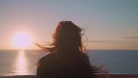 Mujer-Vestida-En-La-Cubierta-De-Un-Crucero-Por-La-Noche,-Sintiendo-El-Viento-Y-El-Cabello-Revoloteando-Con-La-Puesta-De-Sol.