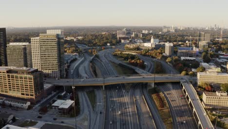 Aerial-of-Atlanta-Midtown-Interstate-freeway-flowing-traffic,-skyline-corporate-office-buildings-of-Wells-Fargo-and-Microsoft