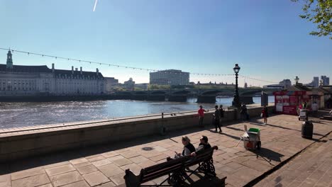 Gente-Durante-El-Día-Soleado-En-Albert-Embankment-Con-El-Puente-De-Westminster-Al-Fondo-En-Westminster,-Ciudad-De-Londres,-Inglaterra