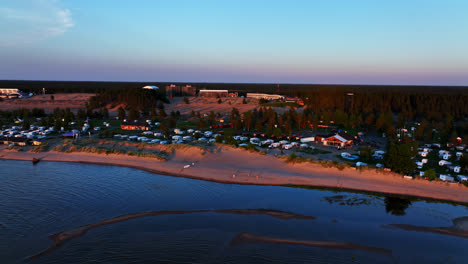 Toma-Aérea-De-Seguimiento-De-La-Playa-Y-La-Zona-De-Acampada,-Atardecer-De-Verano-En-Kalajoki,-Finlandia.