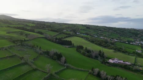 The-beauty-of-the-Açores,-Portugal,-as-seen-from-a-spinning-aerial-perspective,-showcasing-vibrant-landscapes-and-thriving-agricultural-activities