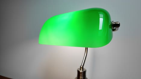 Green-Reading-Lamp-On-Wooden-Desk-In-The-Library