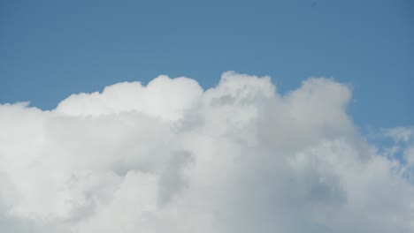 Flauschige-Weiße-Wolken-Ziehen-Im-Zeitraffer-Schnell-über-Einen-Strahlend-Blauen-Himmel