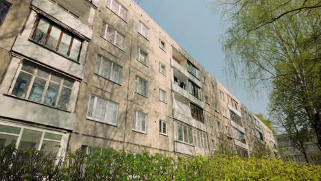 Antiguo-Bloque-De-Apartamentos-Ex-Soviético-Con-Ventanas-En-Un-Verde-Paisaje-Primaveral