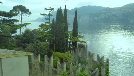 Erleben-Sie-üppige-Vegetation-Und-Majestätische-Zypressen,-Die-Den-Gardasee-Vor-Der-Kulisse-Der-Italienischen-Regionen-Venetien-Und-Lombardei-Umrahmen
