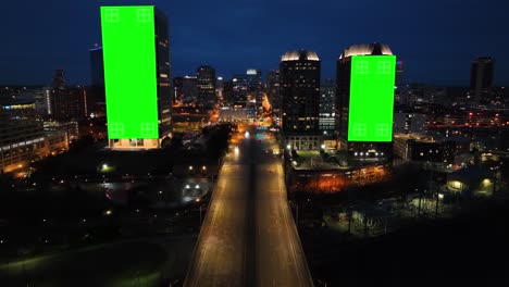 Grüne-Bildschirme-An-Wolkenkratzern-In-Amerikanischen-Städten-Bei-Nacht
