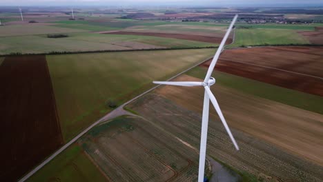 Turbina-Eólica-En-Primer-Plano,-Seguimiento-De-Drones-Al-Atardecer,-Paisaje-Francés