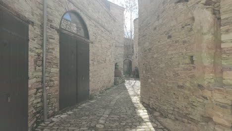 An-old-cobbled-alleyway-in-Lefkara,-lined-with-historical-stone-buildings,-providing-a-glimpse-into-the-village's-past