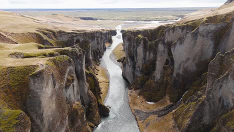 Acantilados-Afilados-Y-Río-Que-Fluye-En-El-Cañón-Fjadrargljufur-En-Islandia