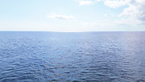 Eine-Drohne-Sinkt-Mit-Wunderschönen,-Faszinierenden-Tropischen-Blauen-Wellen-Auf-Die-Wasseroberfläche-Des-Ozeans