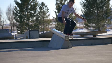 Skater-Macht-Im-Winter-Tricks-Auf-Dem-Geländer-Im-Skatepark