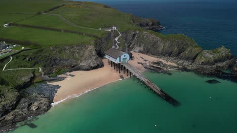 RNLI-Padstow-Lifeboat-Station-from-an-Aerial-Drone-Panning-Over-the-Cornish-Coastline-with-Beautiful-Scenery,-Cornwall,-UK