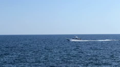 Un-Barco-Solitario-Navega-A-Través-Del-Vasto-Océano-Azul-Bajo-Un-Cielo-Despejado