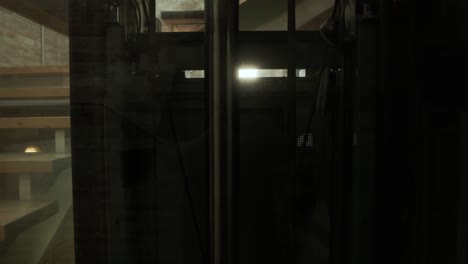 Rückansicht-Durch-Glasgehäuse-Eines-Aufzugs,-Der-Im-Gebäude-Nach-Oben-Fährt