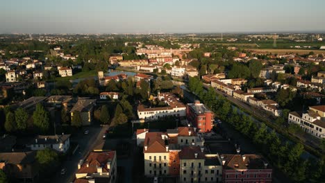 Flying-Over-The-Houses-In-Mira-Comune-By-Naviglio-del-Brenta-At-Sunset-In-Veneto,-Italy