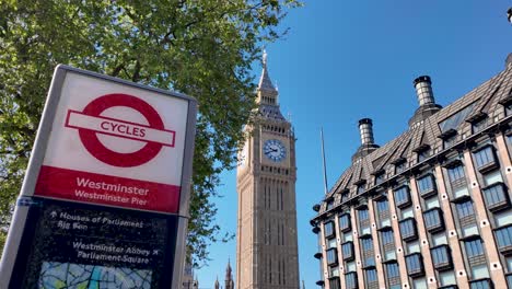 Observing-Portcullis-House-in-London,-with-Big-Ben-gracing-the-skyline-and-a-bike-rental-panel-nearby,-embodies-the-concept-of-modern-urban-infrastructure-and-sustainable-transportation