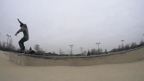 Skater-does-a-kickflip-grind-on-the-skatepark-ledge