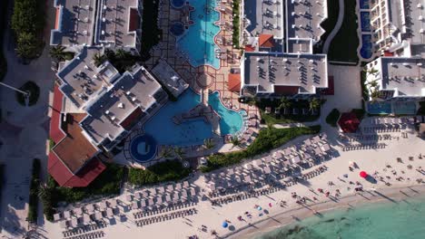 Birdseye-Aerial-View-of-Luxury-Beachfront-Tropical-Hotel-Resort-Buildings-and-Swimming-Pool