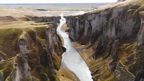 Fjadrargljufur-canyon-landscape-with-flowing-river-between-cliffs