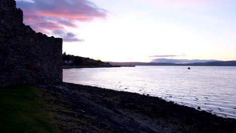 Beautiful-scenic-view-overlooking-ocean-and-Lochranza-Castle-during-twilight-sunset-on-the-remote-Isle-of-Arran-in-Western-Scotland-UK