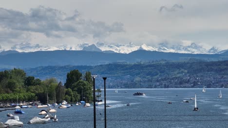 Slow-forward-moving-drone-shot-showing-Lake-Zurich-and-the-southern-snow-capped-Swiss-alps-in-the-distance
