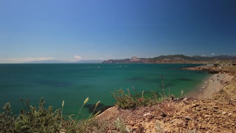 Crimea,-Cabo-Megan,-Surfistas-Con-Una-Vela-Atravesando-Las-Verdes-Aguas-Del-Mar-Negro-En-Primavera
