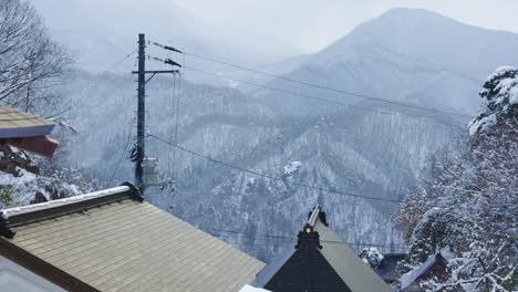 Snow-Falling-on-Roofs-of-Yamadera-Temple-in-Japan,-Slow-Pan-Shot-in-4k