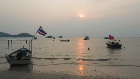 Aerial-Low-Flying-Past-Small-Boat-Moored-At-Ao-Suan-Yai-Beach-At-Koh-Mak-Island-During-Golden-Hour-Sunset