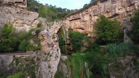 Breathtaking-view-of-Sant-Miquel-del-Fai-waterfall-in-Barcelona,-surrounded-by-lush-cliffs