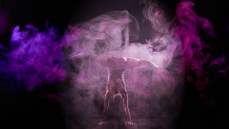 Akrobat-Macht-Handstand-Und-Flexible-Beinbewegungen-Mit-Rosa-violettem-Rauch
