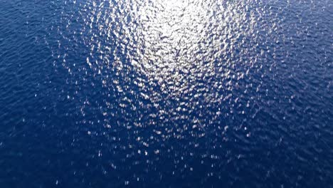 Sunlight-rounded-beam-spreads-across-textured-ocean-water-surface,-natural-background