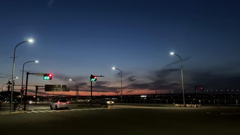 Paisaje-Urbano-Crepuscular-Con-Semáforos-Y-Carreteras-Vacías,-Vibrante-Cielo-Al-Atardecer-En-El-Fondo