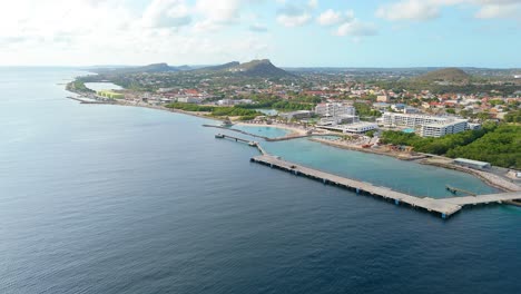 Aerial-ascend-above-empty-cruise-ship-port-dock-on-coastline-of-Curacao