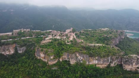 Siurana,-Un-Pueblo-Histórico-Encaramado-Sobre-Un-Acantilado-En-Tarragona,-Con-Un-Entorno-Exuberante,-Vista-Aérea