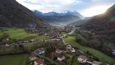 Hermoso-Amanecer-Iluminando-Una-Pequeña-Ciudad-Europea-Con-Picos-Nevados-Al-Fondo