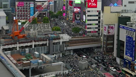 Slow-tilt-up-reveal-over-busy-Tokyo-Shibuya-Station-at-dusk---panorama-view