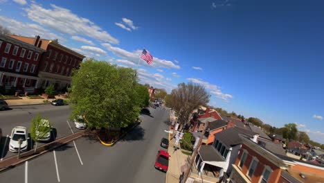 American-town-square-with-USA-flag-and-quaint-buildings-on-bright-spring-day