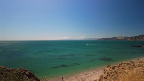 Crimea,-Cabo-Megan,-Surfistas-Con-Una-Vela-Atravesando-Las-Verdes-Aguas-Del-Mar-Negro