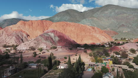 Aerial-view-of-Cerro-Siete-Colores-and-rural-houses-in-the-tourist-town-of-Purmamarca-in-Jujuy,-Argentina