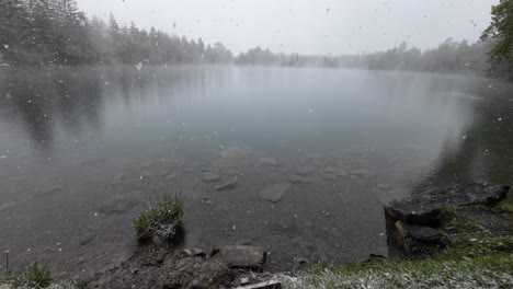 Schnee-Fällt-Sanft-Auf-Einen-Mystischen-See-Mit-Kristallklarem-Wasser,-Umgeben-Von-Wald
