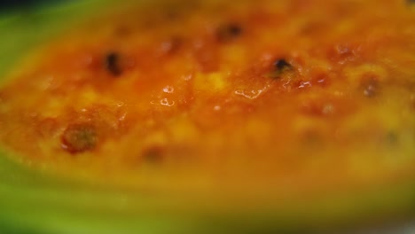 Macro-detailed-video-of-a-sliced-sabra,-orange-open-tropical-cactus-fruit-with-seeds,-smooth-pull-back-movement,-slow-motion-120fps