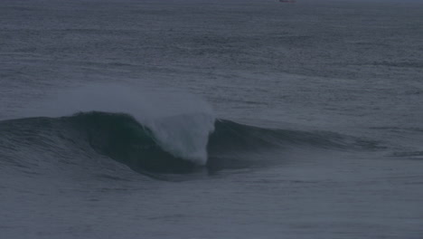 Ocean-wave-with-split-peak-erupts-into-whitewash-as-lip-hits-surface,-slow-motion