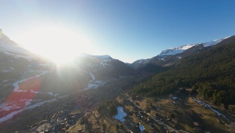 Bright-sunlight-over-mountain-ridge-in-Bernese-Alps-of-Switzerland-and-village-of-Grindelwald-below
