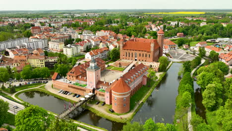 A-broader-perspective-that-includes-fields-surrounding-the-town,-highlighting-the-castle’s-prominence-within-Lidzbark-Warmiński-and-the-integration-of-urban-and-natural-landscapes