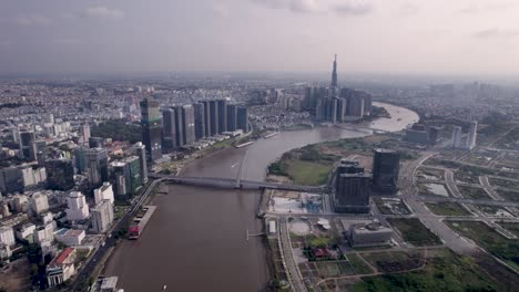 Vista-Aérea-Del-Puente-Ba-Son-Sobre-El-Río-Saigón-En-La-Ciudad-De-Ho-Chi-Minh,-Vietnam,-Con-La-Vista-Del-Emblemático-Edificio-81,-La-Torre-Al-Fondo