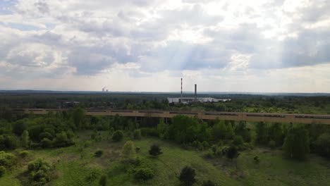 Industrial-and-old-looking-factory-with-chimneys-and-closed-off-and-rusted-transportation-bridge-in-the-front