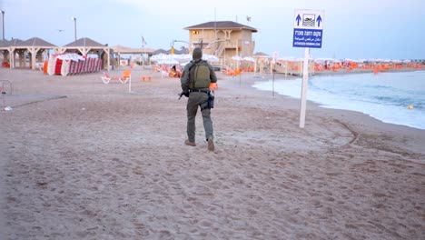 Ein-Israelischer-IDF-Soldat-Joggt,-Um-Die-Sicherheit-Der-Besucher-Am-Strand-Zu-Gewährleisten