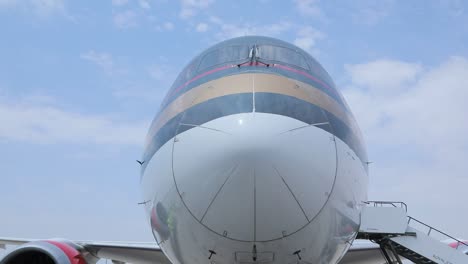 The-scene-captures-the-grounded-airplane's-nose,-highlighting-its-aerodynamic-shape,-cockpit-windows,-and-branding