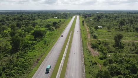 Disparo-De-Un-Dron-Volando-Sobre-Un-Largo-Camino-De-La-República-Dominicana-En-Un-Día-Soleado-De-Verano-Con-Algunos-Autos